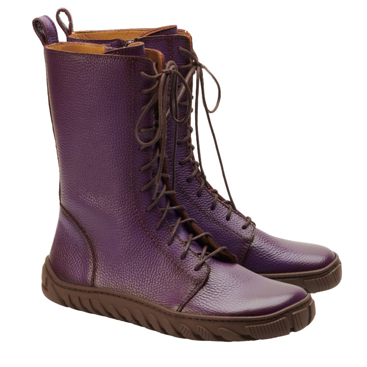 Die DOQS Purple Boots von ZAQQ sind hohe, lilafarbene Schnürstiefel aus Premium Nappaleder mit brauner Sohle. Sie bestechen durch ihre strukturierte Oberfläche und die dünnen braunen Schnürsenkel, die sich vor einem weißen Hintergrund abheben.