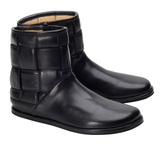 Ein Paar schwarze LUQAS Wide Ankle Boots von ZAQQ aus hochwertigem Nappaleder mit einem markanten Steppmuster an den Seiten und einer glatten Vorderseite vor einem schlichten weißen Hintergrund.