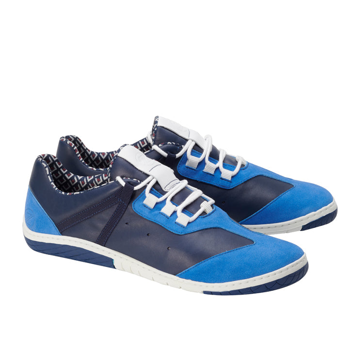 Wir präsentieren den QOAST Blue von ZAQQ: Diese stylischen Sneaker sind aus Nappaleder gefertigt und zeichnen sich durch eine auffällige Kombination aus blauen und marineblauen Einsätzen aus. Ergänzt durch weiße Schnürsenkel und ein gemustertes Innenfutter bieten sie sowohl Komfort als auch Flair. Die Sohlen sind mit der unverwechselbaren ZAQQ MINIMAL Sohle in Weiß gestaltet, hervorgehoben durch marineblaue Akzente für ein elegantes, modernes und sportliches Erscheinungsbild.