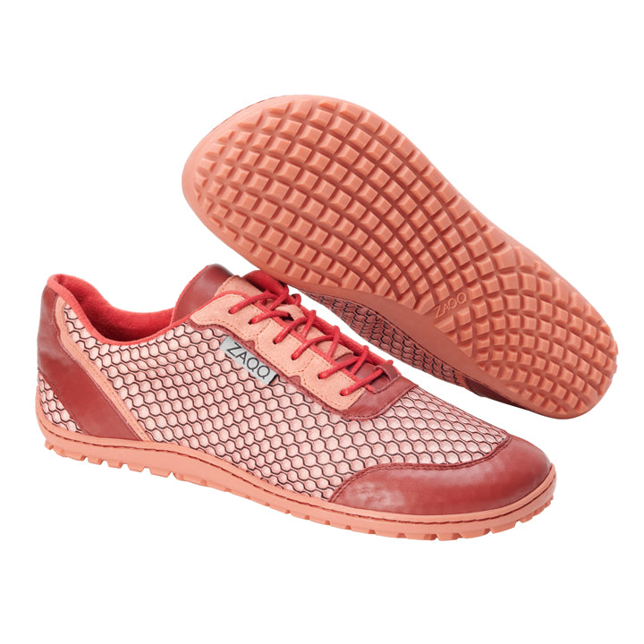 Wir präsentieren den TOQIO Coral von ZAQQ: Diese Sneaker präsentieren sich in einem Farbschema aus Rot und Pink mit einem markanten Wabenmuster. Sie sind mit der ZAQQ Sneakersohle ausgestattet und verfügen über rote Schnürsenkel sowie strukturierte Gummisohlen, die perfekt dazu geeignet sind, ihr kompliziertes Sohlendesign zu präsentieren, wenn man einen Schuh auf die Seite legt.