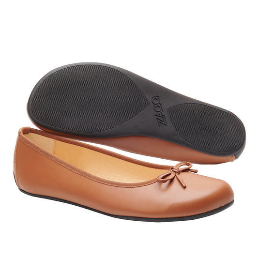 Ein Paar braune ZAQQ LOOQ Vegan Cognac Ballerinas haben eine kleine Schleife an der Spitze. Ein Schuh ist von der Seite zu sehen, während der andere von unten gezeigt wird, wodurch die schwarze Barfußsohle aus Gummi hervorgehoben wird.