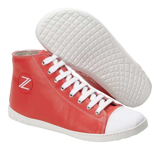 Wir präsentieren die CHUQQS Red High-Top-Sneaker von ZAQQ. Diese auffälligen roten Sneaker haben weiße Sohlen und Schnürsenkel, ergänzt durch eine weiße Zehenkappe. Ein Schuh steht aufrecht und zeigt ein rundes Logo mit dem Buchstaben Z, während der andere auf der Seite liegt und ein kompliziertes Profilmuster zeigt.