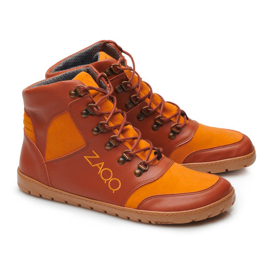 Wir präsentieren den HIQE Vegan Sierra Waterproof von ZAQQ: ein Paar High-Top-Sneaker in Orange und Braun mit ZAQQ-Branding. Diese veganen Wanderschuhe haben braune Schnürsenkel, einen gepolsterten Knöchelkragen und eine strukturierte Sohle.