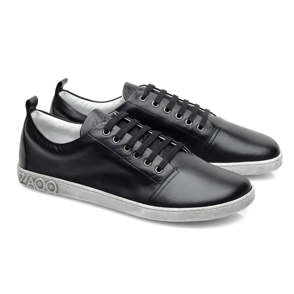 Wir präsentieren den TAQQ Nappa Black von ZAQQ: ein stilvolles Paar eleganter schwarzer Leder-Sneaker aus schwarzem Glanzleder mit schwarzen Schnürsenkeln und weißen Sohlen. Diese Schuhe zeigen ein dezentes Logo an der Seite und verkörpern ein modernes minimalistisches Design mit verbessertem Tragekomfort für sowohl legere als auch halblegere Anlässe.